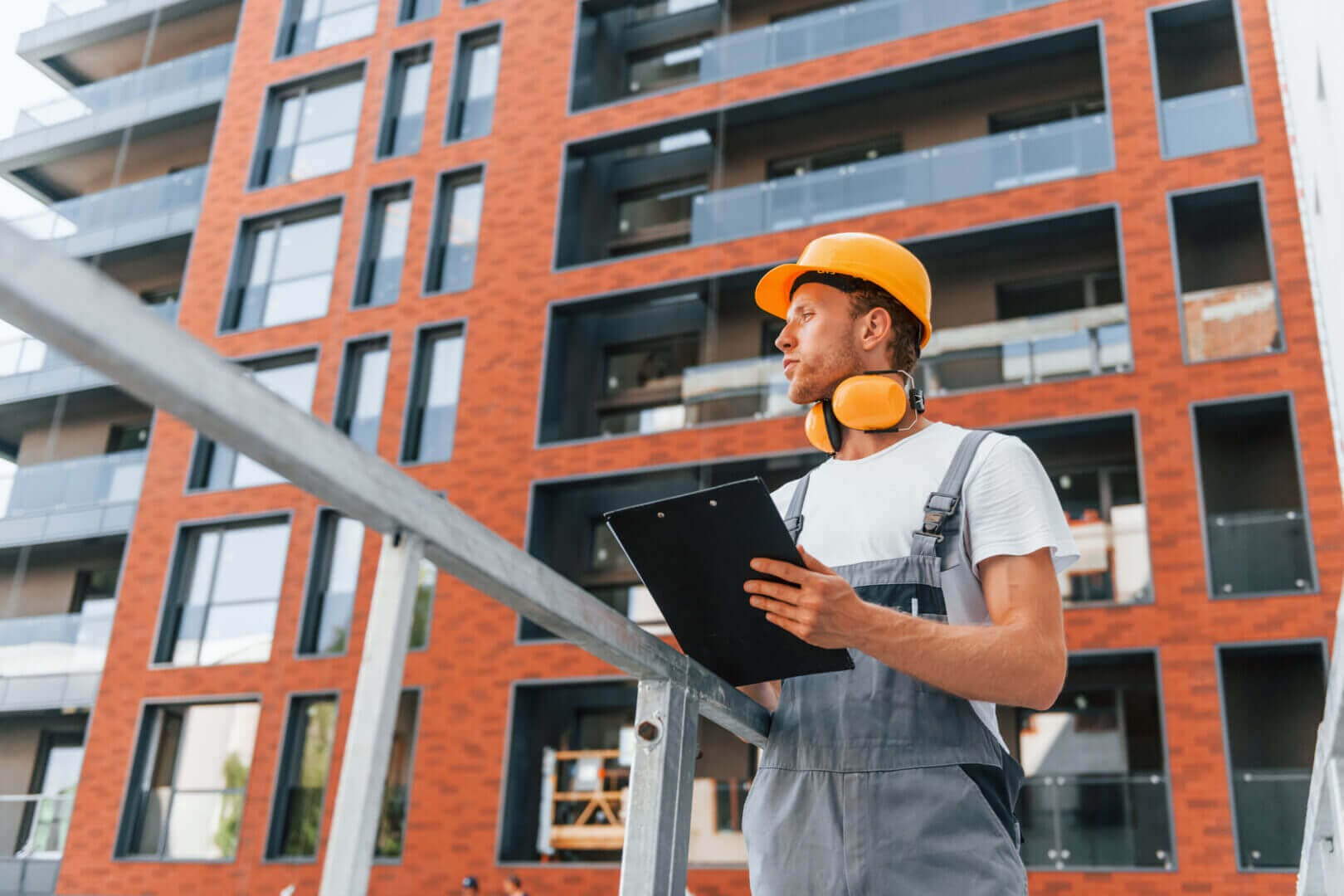 Construction worker with clipboard in front of a building, Fully licensed and insured Home Inspectors in Bergen County, NJ. Owned by Herman Andrade, Saddle Brook, NJ.